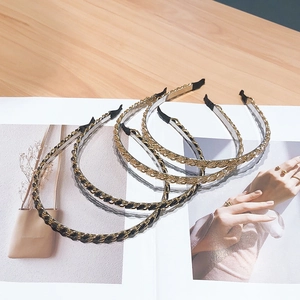 Set of five elegant metal chain headbands in gold and black on an open magazine