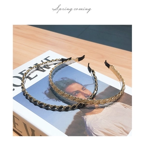 Close-up of elegant gold and black metal chain headbands on a fashion magazine