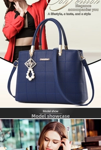 Detail of navy quilted tote bag with pearl pendant and gold metal hardware