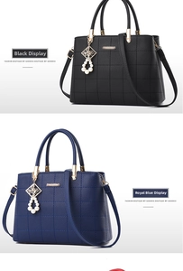 Detail of lychee pattern leather handbag featuring pearl charm and golden hardware