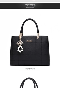 Front view of black pebbled tote bag with cross-stitched pattern and pearl metal pendant