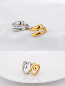 Polished teardrop shaped open rings in gold and silver finish on white background