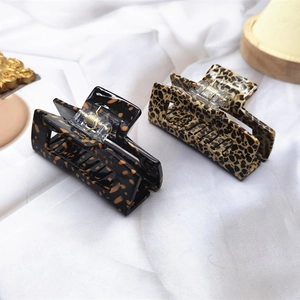 Detail view of two medium acetate hair claws with vintage leopard and tortoise patterns