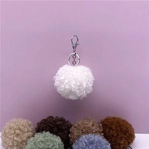 Close-up of soft curly fur ball keychain with silver metal ring and color options.