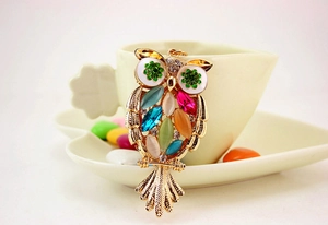 Detailed macro view of crystal owl pendant with colorful gemstones and rhinestones