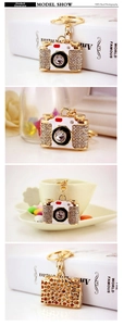 Close-up of vintage camera keychain with sparkling rhinestones and golden alloy detail