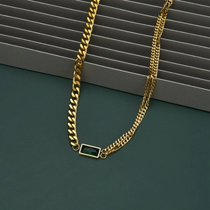 Detail of emerald cut green zircon on asymmetrical gold-plated stainless steel chain