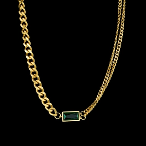 Detail of gold Cuban chain necklace featuring an emerald-green rectangular zircon stone