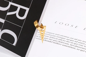 Détail d'une boucle d'oreille triangle dorée géométrique sur fond élégant en noir et blanc