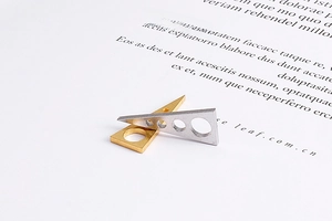 Vue détaillée des pendentifs triangulaires minimalistes avec découpes circulaires en or et argent