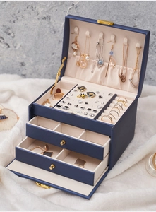 Detailed top view of 3-tier jewelry box with beige velvet lining and drawer compartments
