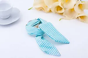 Detailed close-up of a blue and white striped fabric strap watch with a round metal dial