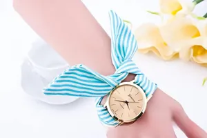 Detail of a Geneva women's watch featuring a blue and white striped fabric bow strap