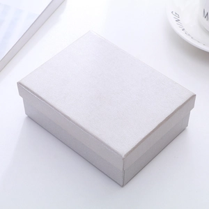 Close-up of textured silver jewelry gift box on white desk with aesthetic setup
