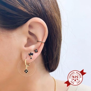 Macro shot of S925 sterling silver ear cuff set with black gemstones and gold plating