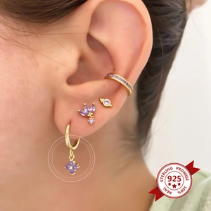 Macro shot of S925 sterling silver earrings with purple zircons on a gold plated base