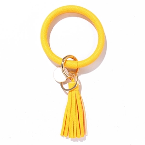 Detail of yellow PU leather tassel keychain with wooden beads and golden metal keyring