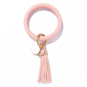 Pink leather O-ring keychain bracelet with golden spring clasp and long tassel detail