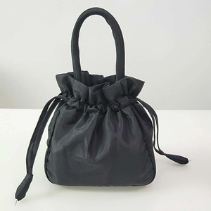 Detail of black drawstring bucket bag showing polished fabric texture and dual handles