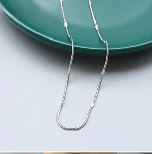 Detail of 1.3mm steel snake bone chain necklace with embossed metal texture