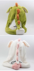 Detail of plush dinosaur cap with movable ears and soft velvet texture in green and white