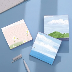 Detailed close-up of cute landscape illustration sticky notes on a blue office desk