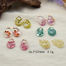 Macro detail of resin cherry pendant with dried flowers and dimensions 16.7x27mm