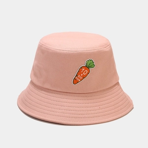 Dettaglio del cappello a secchiello in cotone rosa con ricamo di carota e cuciture fini
