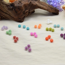 Flat lay of colorful matte spherical resin beads on linen with lavender for DIY jewelry