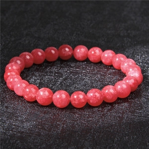Macro detail of 8mm natural red strawberry quartz beads on a stretch bracelet