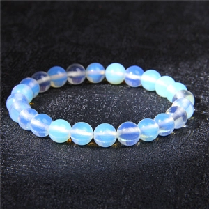 Macro detail of 8mm translucent blue natural stone beads with soft white sheen on black texture