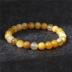 Macro shot of 8mm honey yellow agate beads bracelet with natural striped textures