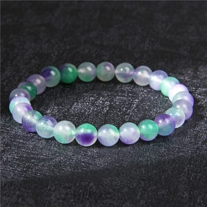 Detailed macro shot of 8mm purple and green natural fluorite stone beads on elastic bracelet