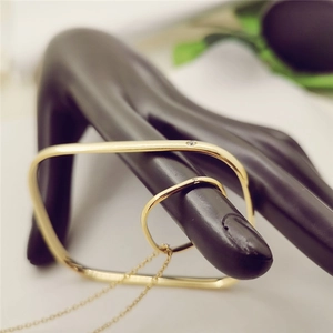 Detailed shot of a gold titanium steel square bangle and necklace on a hand model display