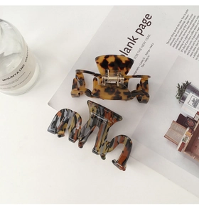 Detail of tortoise shell and striped acetate hair claws on a bright aesthetic background