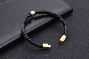 Détail du bracelet en cuir tressé avec fermoir magnétique doré sur pochette en cuir