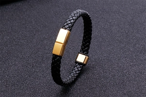 Détail du bracelet en cuir tressé noir avec fermoir magnétique doré poli et pièces en métal