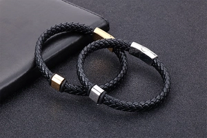 Détail de bracelets en cuir noir tressé avec fermoirs magnétiques en acier inoxydable