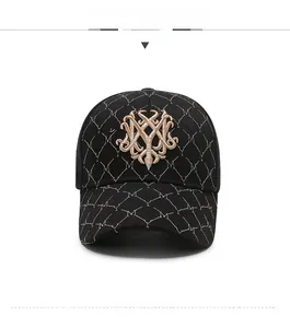 Close-up of black baseball cap featuring quilted diamond patterns and golden embroidery
