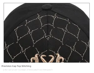 Close-up of black baseball cap with gold geometric stitching and embroidery details