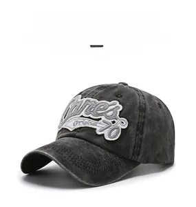 Détail d'une casquette vintage en coton délavé anthracite avec broderie blanche rétro
