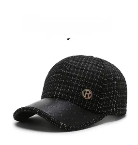 Detail of tweed baseball cap with embossed leather brim and golden metal R logo