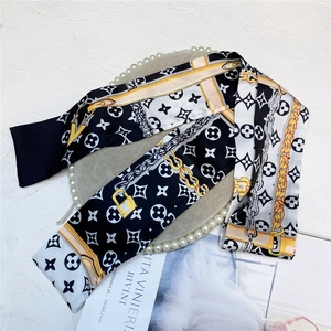 Elegant satin twilly headband with black and white monogram pattern and gold chain motifs