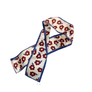Detail of satin floral twilly scarf with red vintage flower print and blue edges