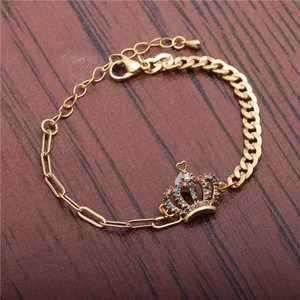Detailed macro view of gold crown charm bracelet with colorful rhinestones on wood
