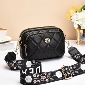 Elegant black quilted crossbody bag with triple zippers and floral wide shoulder strap