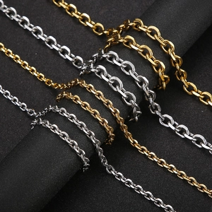Sleek gold and silver stainless steel cable chain necklace set on a dark textured base