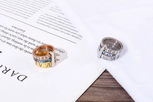 Detail of Roman numeral ring set with shell inlay and zircon on a magazine background