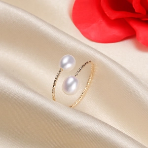 Minimalist gold plated open ring with two freshwater pearls on silk background