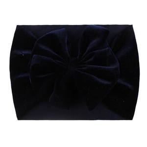 Detail view of navy blue velvet baby headband with large bowknot on white background